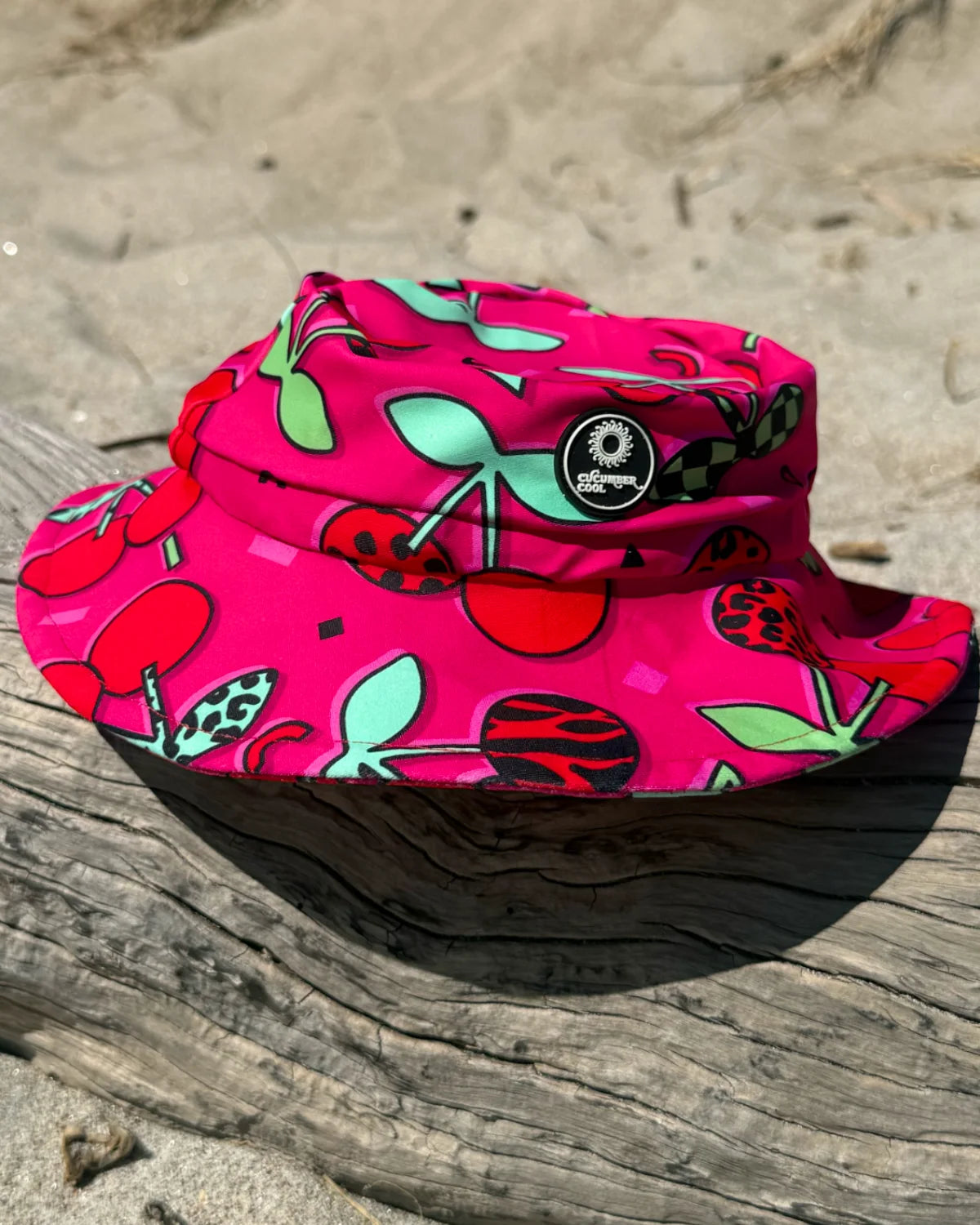 Cherry Pop kids swim bucket hat with chin strap, worn at the beach – bright UPF50+ round brim beach hat by Cucumber Cool