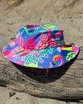 Club Tropicana tropical print kids swim bucket hat with chin strap, worn at the beach – bright UPF50+ round brim beach hat by Cucumber Cool