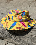 Surf's Up! kids swim bucket hat with chin strap, worn at the beach – bright UPF50+ round brim beach hat by Cucumber Cool